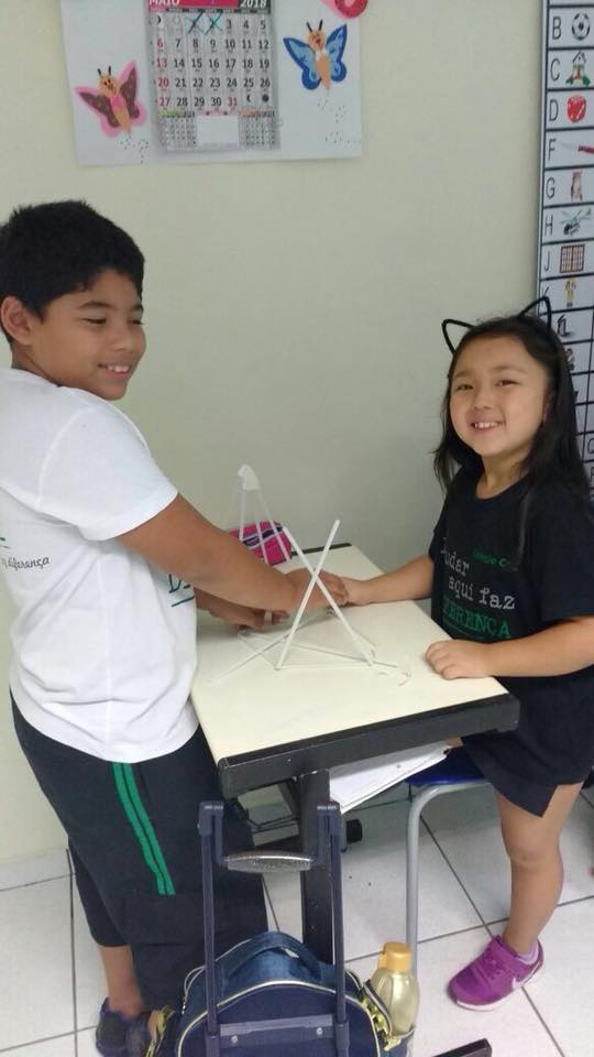 menino e menina construindo modelo de poliedro
